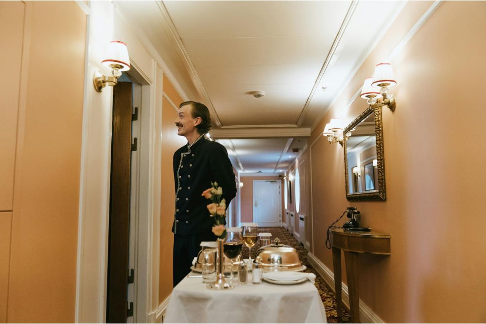 Hospitality intern assisting guests in a luxury hotel